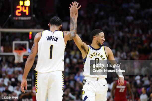 Obi Toppin and Tyrese Haliburton of the Indiana Pacers high five during the second quarter of the game against the Miami Heat at Kaseya Center on...