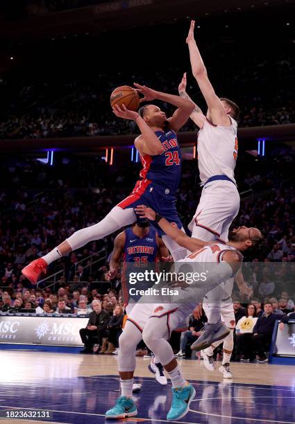 Kevin Knox II of the Detroit Pistons heads for the net as Isaiah Hartenstein and Jalen Brunson of the New York Knicks defend in the second half at...