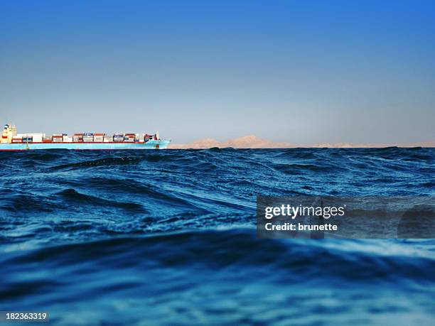 cargo ship on the horizon of the ocean - red sea stock pictures, royalty-free photos & images