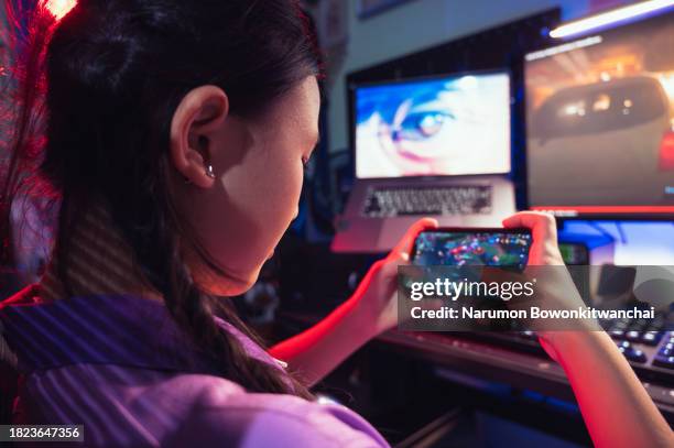 teenager woman playing esports and video games via smartphone at home with futuristic lighting settings - streaming service stock pictures, royalty-free photos & images