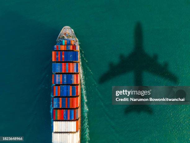 aerial view of a cargo ship in a thriving harbor - globalization stock pictures, royalty-free photos & images