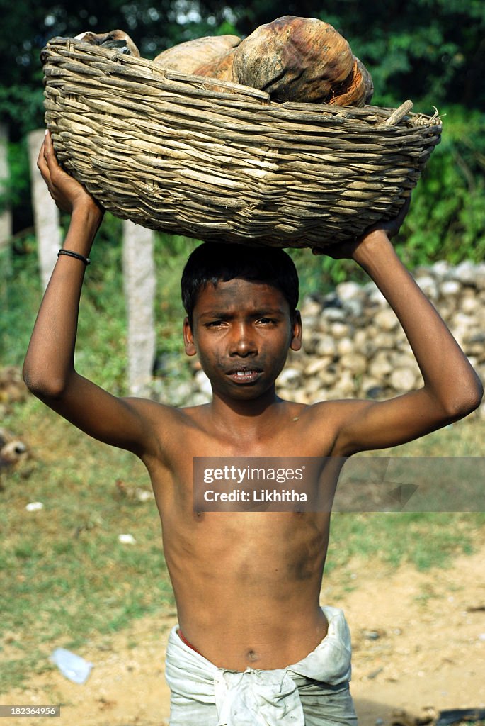 Dirty child carrying items gathered in third world country