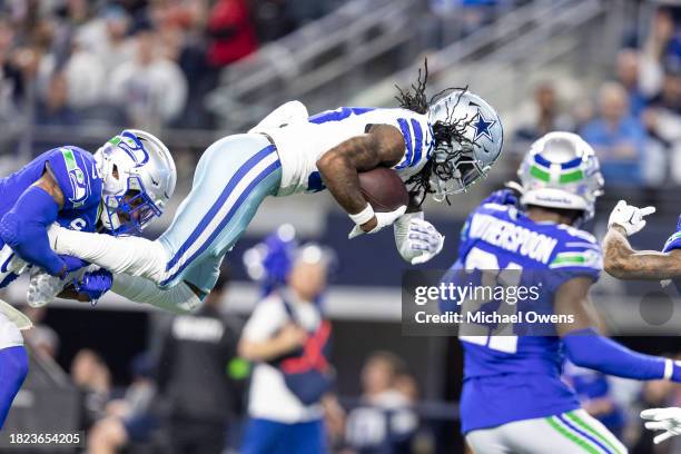 CeeDee Lamb of the Dallas Cowboys dives as he's tackled by Quandre Diggs of the Seattle Seahawks during an NFL football game between the Dallas...