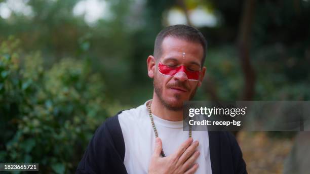 spiritual man meditating in nature - new age stock pictures, royalty-free photos & images