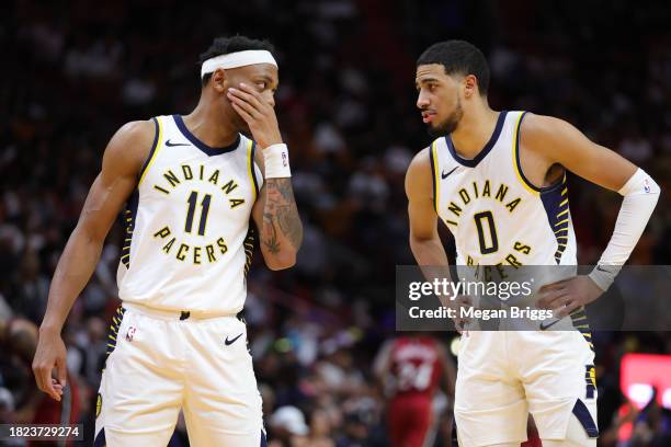 Bruce Brown and Tyrese Haliburton of the Indiana Pacers speak on the court during the third quarter of the game against the Miami Heat at Kaseya...