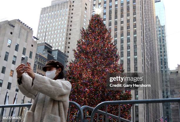 Woman takes a selfit in front of the Rockefeller Center Christmas tree the morning after it was lit on November 30 in New York City.