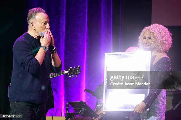 Bruce Springsteen reacts as Darlene Love holds her Platinum record during the "Love For The Holidays" concert at Town Hall on November 30, 2023 in...