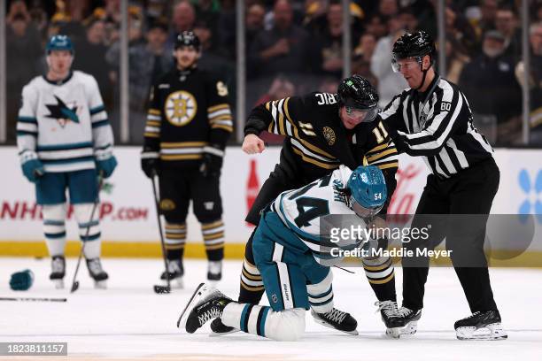 Trent Frederic of the Boston Bruins punches Givani Smith of the San Jose Sharks during the second period at TD Garden on November 30, 2023 in Boston,...