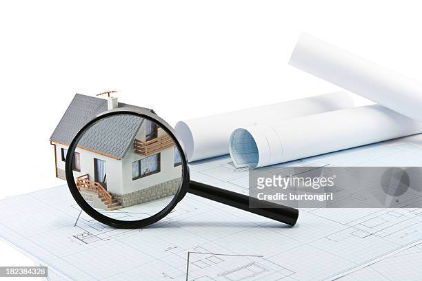 plans with a model house and a magnifying glass on top - loup stockfoto's en -beelden
