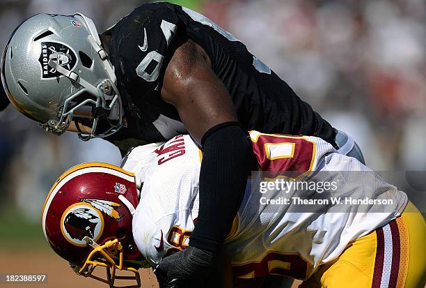 Kevin Burnett of the Oakland Raiders tackles Pierre Garcon of the Washington Redskins during the second quarter at O.co Coliseum on September 29,...