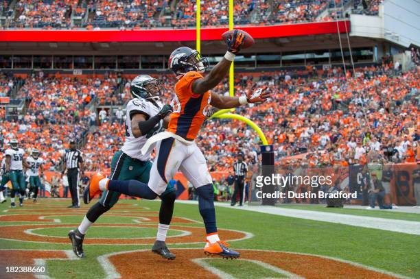 Wide receiver Demaryius Thomas of the Denver Broncos scores a third quarter touchdown under coverage by cornerback Bradley Fletcher of the...