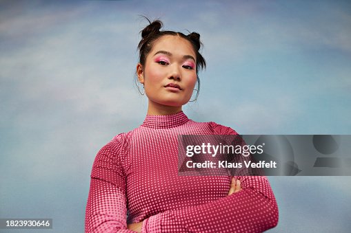 Portrait of confident teenage girl with arms crossed against colored background Portrait of confident teenage girl with arms crossed against colored background