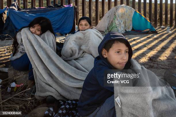 Asylum seekers wrapped in blankets are seen at a makeshift camp after crossing the nearby border with Mexico near the Jacumba Hot Springs on November...