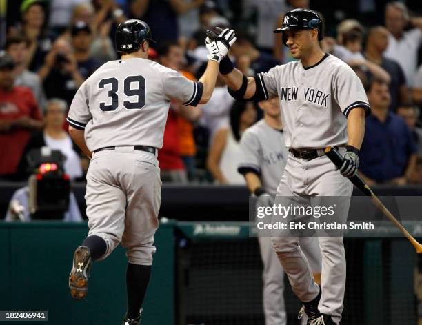 Mark Reynolds of the New York Yankees is congratulated by teammate Travis Hafner after Reynolds hit a solo home run during the fourteenth inning...