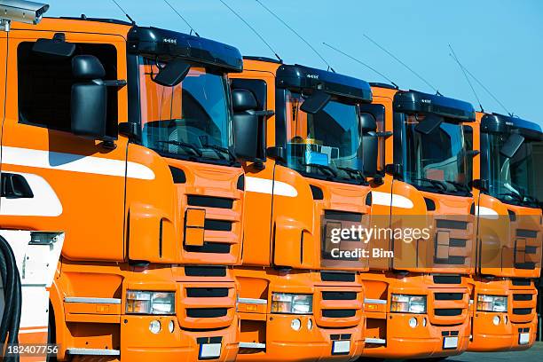 fila de orange semi camiones - convoy fotografías e imágenes de stock