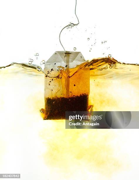 teabag in hot water - tea bags stock pictures, royalty-free photos & images