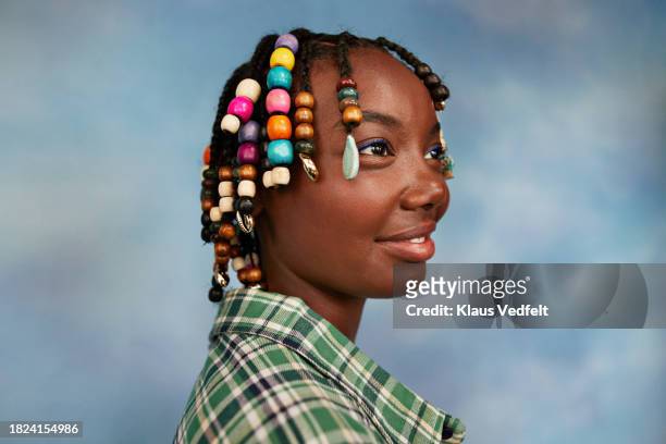 contemplative teenage girl with beads on braids by colored background - blank black shirt stock pictures, royalty-free photos & images