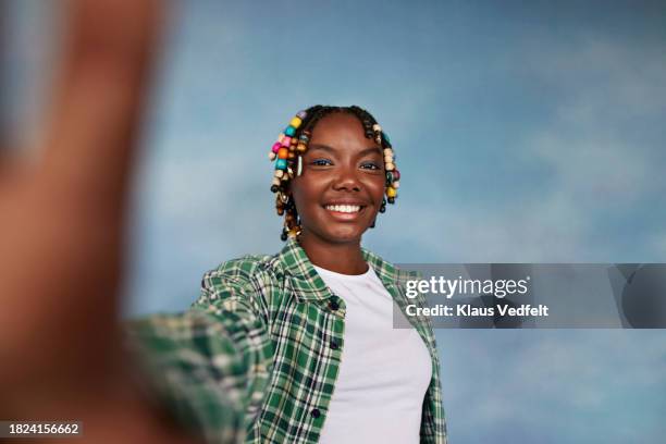 portrait of smiling teenage girl wearing plaid shirt standing against colored background - blank black shirt stock pictures, royalty-free photos & images