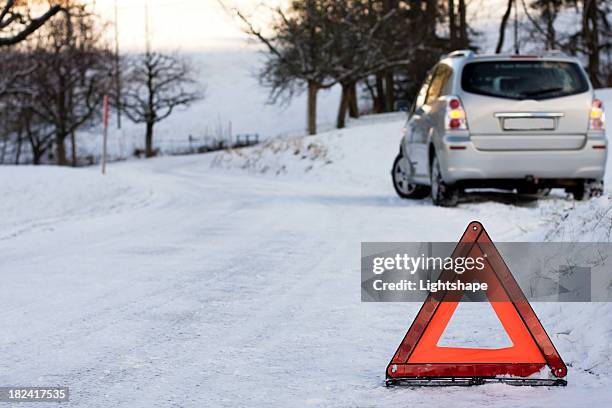 suv stuck on a snowy road, protected by a hazard sign - hazard light stock pictures, royalty-free photos & images