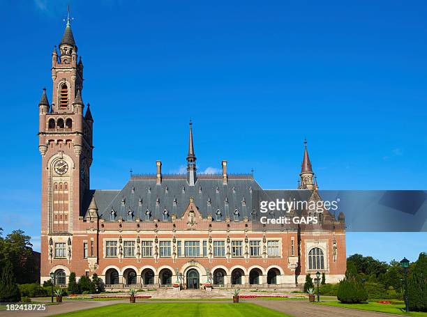 exterior of the hague's peace palace against a blue sky - the hague stock pictures, royalty-free photos & images
