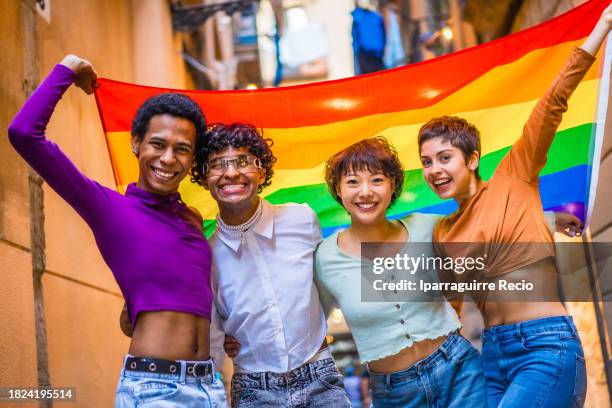 portrait of a multiethnic diversity lgbt group with rainbow flag. multiracial friends having fun in the city at the pride march. homosexual, lesbian, bisexual, non-binary concept - choice music group stock pictures, royalty-free photos & images