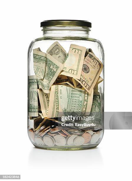 a clear glass jar filled with cash and coins  - donate money stock pictures, royalty-free photos & images