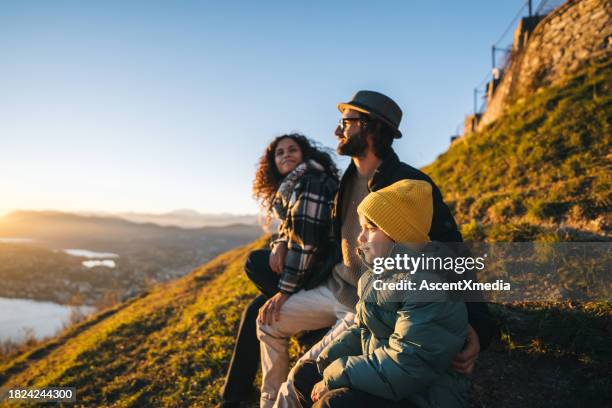 family enjoys time together on mountain top - blue coat stock pictures, royalty-free photos & images