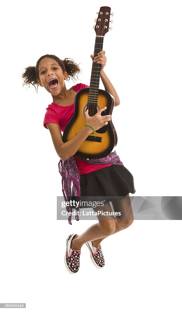 Elementary age female jumping in air and playing guitar