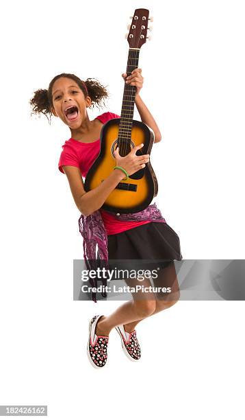 elementary age female jumping in air and playing guitar - air guitar stockfoto's en -beelden