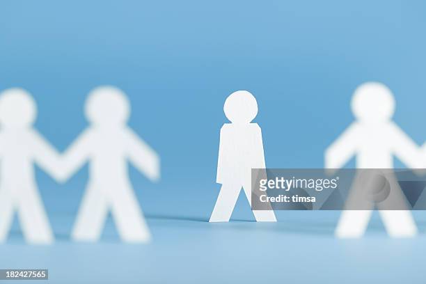 paper figures holding hands with one alone not participating - exclusion stock pictures, royalty-free photos & images
