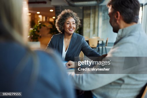 Happy insurance agent talking to her customers in the office. Happy insurance agent talking to her customers in the office.