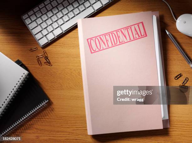 confidential folder on a desk - top secret confidential stock pictures, royalty-free photos & images