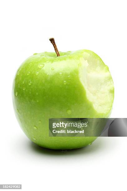 bite on a green apple - apple bite out stock pictures, royalty-free photos & images