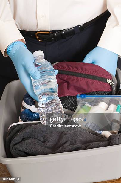 airport security tsa agent finds a bottle of water - tsa stock pictures, royalty-free photos & images