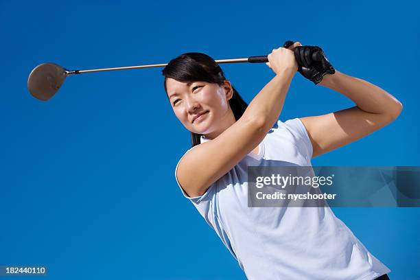 young female golfer teeing off - golf girls stock pictures, royalty-free photos & images