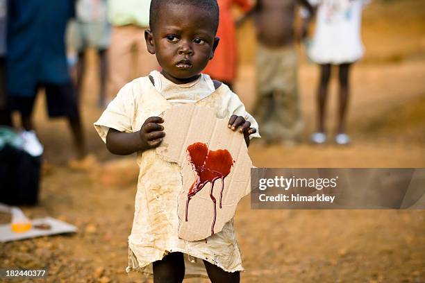 african boy holding a cardboard africa cutout - 1 year poor african boy stock pictures, royalty-free photos & images