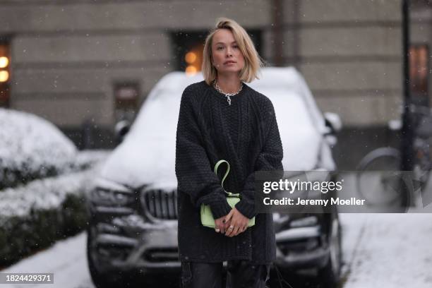 Nadine Berneis seen wearing Black Palms the label dark grey / black wool cable knit sweater, silver earrings, Glambou silver chain necklace, Young...