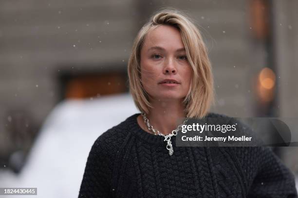 Nadine Berneis seen wearing Black Palms the label black wool cable knit sweater, silver earrings, Glambou silver chain necklace, on November 29, 2023...