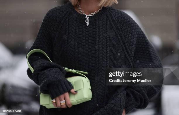 Nadine Berneis seen wearing Black Palms the label black wool cable knit sweater, silver earrings, Glambou silver chain necklace, Bottega Veneta light...