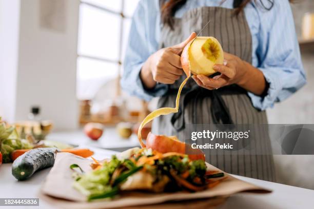 close up shot of unrecognisable woman peeling off apple in a domestic kitchen - leftovers stock pictures, royalty-free photos & images