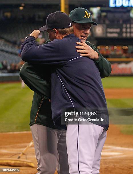 Manager Eric Wedge of the Seattle Mariners gets a hug from manager Bob Melvin of the Oakland Athletics after the Athletics defeated the Mariners 9-0...