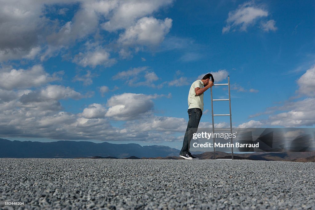 Man standing near ladder with looking down