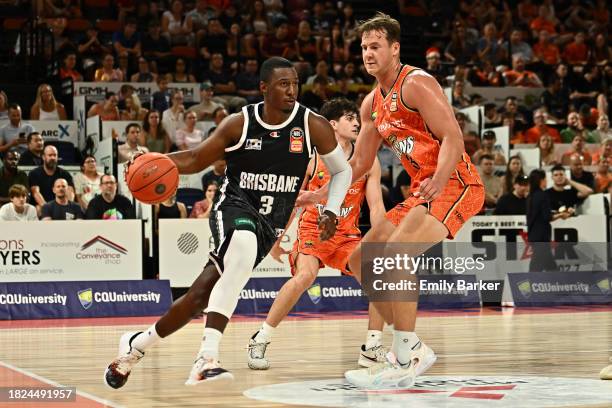 Shannon Scott of the Bullets drives up court under pressure from Sam Menninga of the Taipans during the round nine NBL match between Cairns Taipans...
