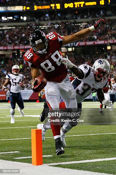 Tony Gonzalez of the Atlanta Falcons scores a touchdown against the defense of Alfonzo Dennard of the New England Patriots during the game at Georgia...