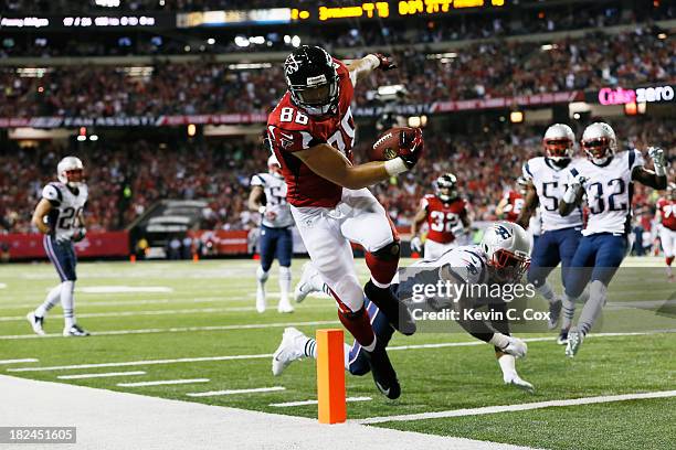 Tony Gonzalez of the Atlanta Falcons scores a touchdown against the defense of Alfonzo Dennard of the New England Patriots during the game at Georgia...