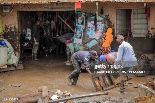 People collect belongings in an area affected by landslides and flooding triggered by heavy rainfall in Katesh, Tanzania on December 3, 2023....