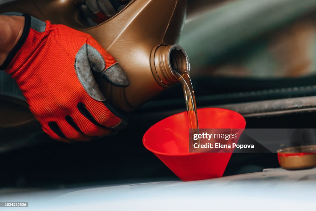 Pouring Motor Oil To Car Engine, Red Funnel And Gloves Using For Works