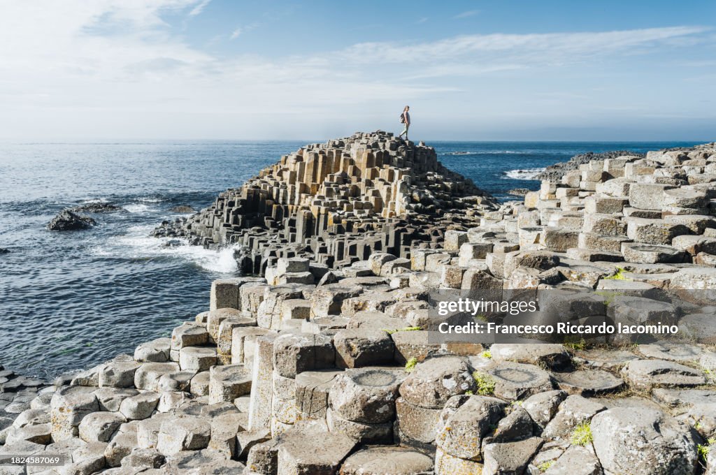 Woman exploring Giant's Causeway. Europe, United Kingdom, Northern Ireland, County Antrim, Ulster Region.
