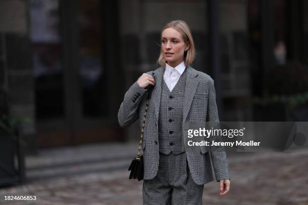 Marlies Pia Pfeifhofer seen wearing silver earrings, white cotton buttoned blouse / shirt, Dior black / white herringbone checked pattern suit vest /...