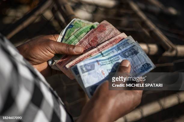 Shop owner counts Ethiopian Birr in his stall at the Shola Market in Addis Ababa on December 4, 2023.